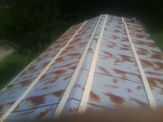 Rusted metal roof panels with new wood purlins before replacement — Storm Damage Roof Repair in Frisco by Roofing Brothers