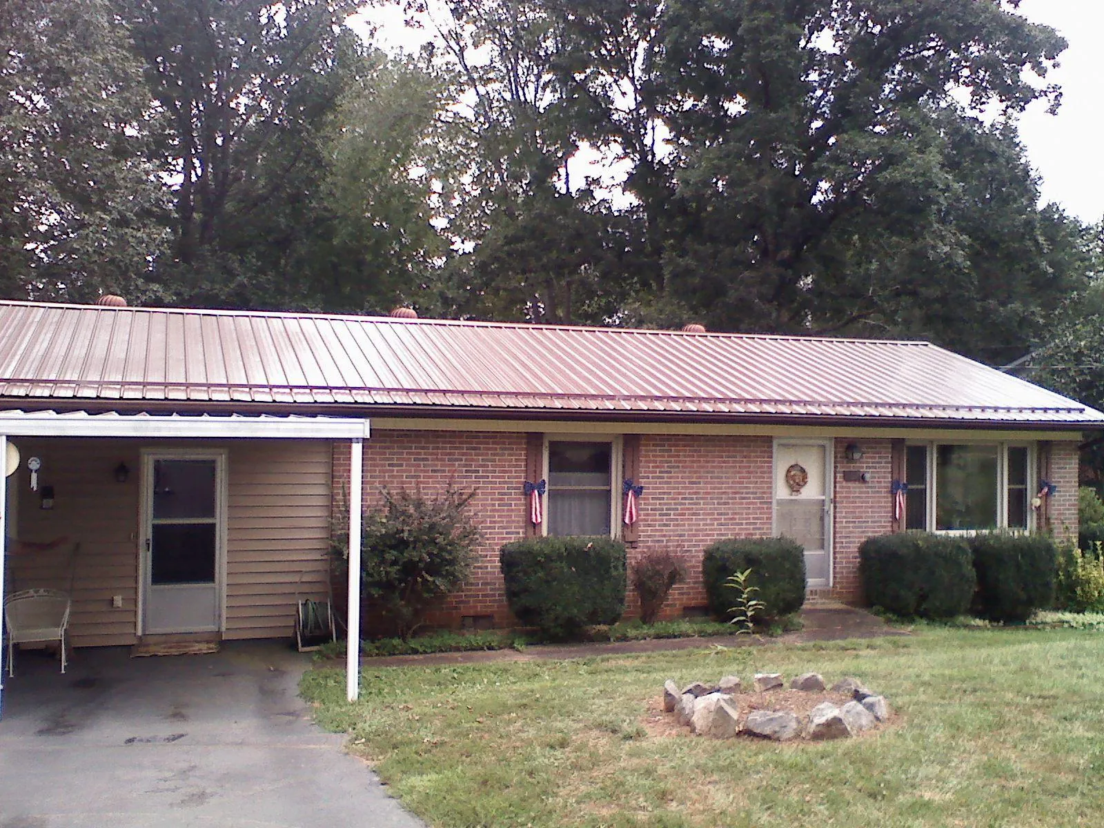 Bronze metal roof and carport on a brick ranch home — Roof Repair work by our crew in Frisco